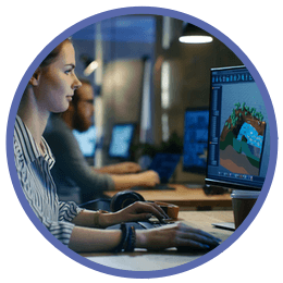 Kvinna sitter framför en dator och utvecklar ett spel för en svensk speltillverkare
