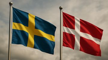 Två flaggstänger, på den ena finns svenska flaggan och på den andra den danska flaggan.