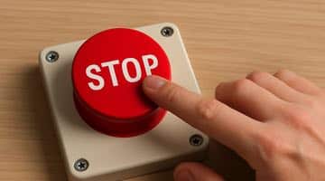 En person trycker på en röd stoppknapp. Bilden ska symbolisera en person som stänger av sig från spel.