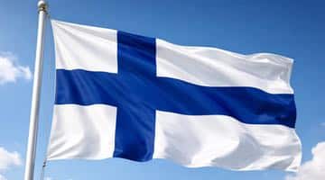 En finsk flagga som vajar i vinden. I bakgrunden syns blå himmel med molntussar.